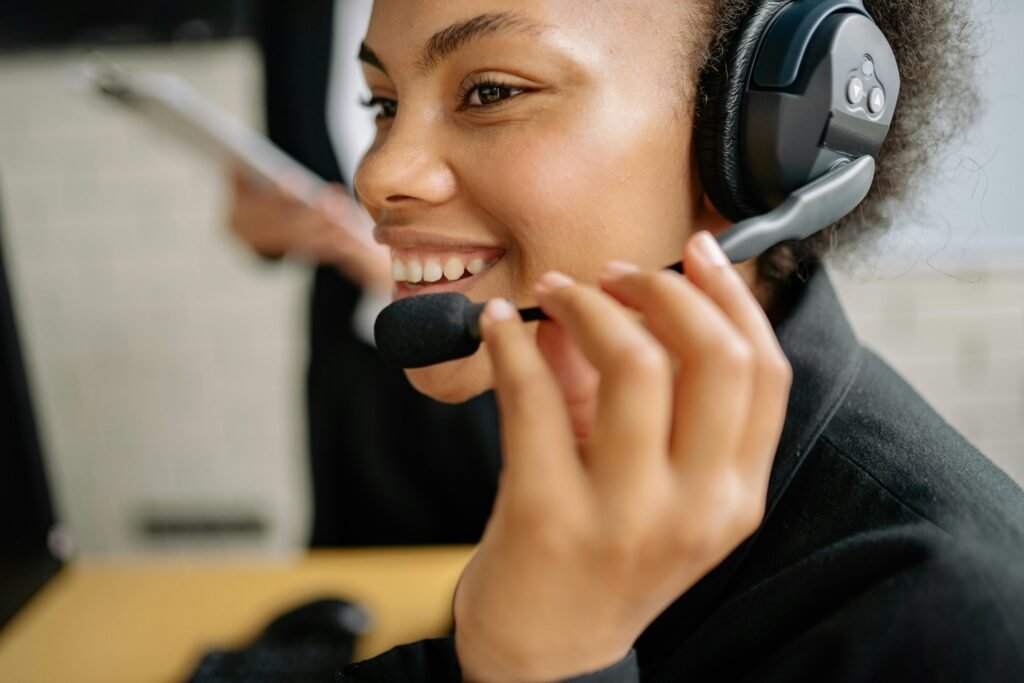 Portrait of a smiling call center agent wearing a headset in an office setting.