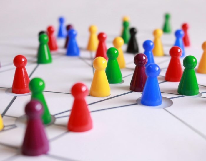 A strategic arrangement of colorful pawns connected on a game board, symbolizing networking and teamwork.